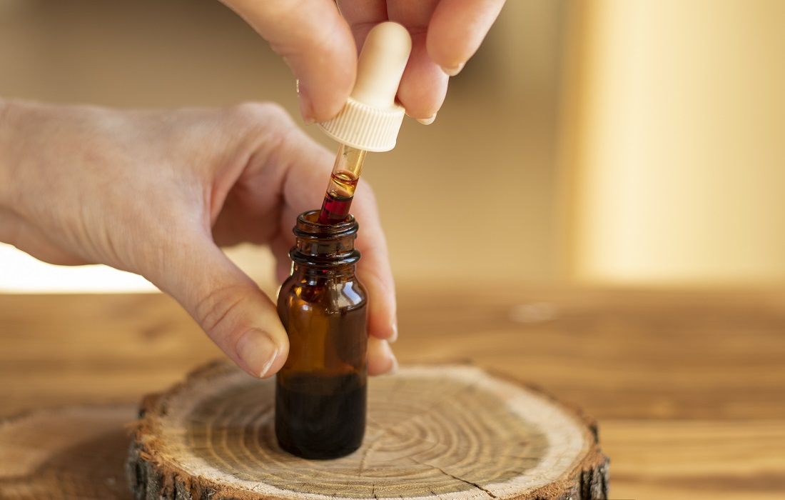 A drop of serum with a pipette drips for skincare